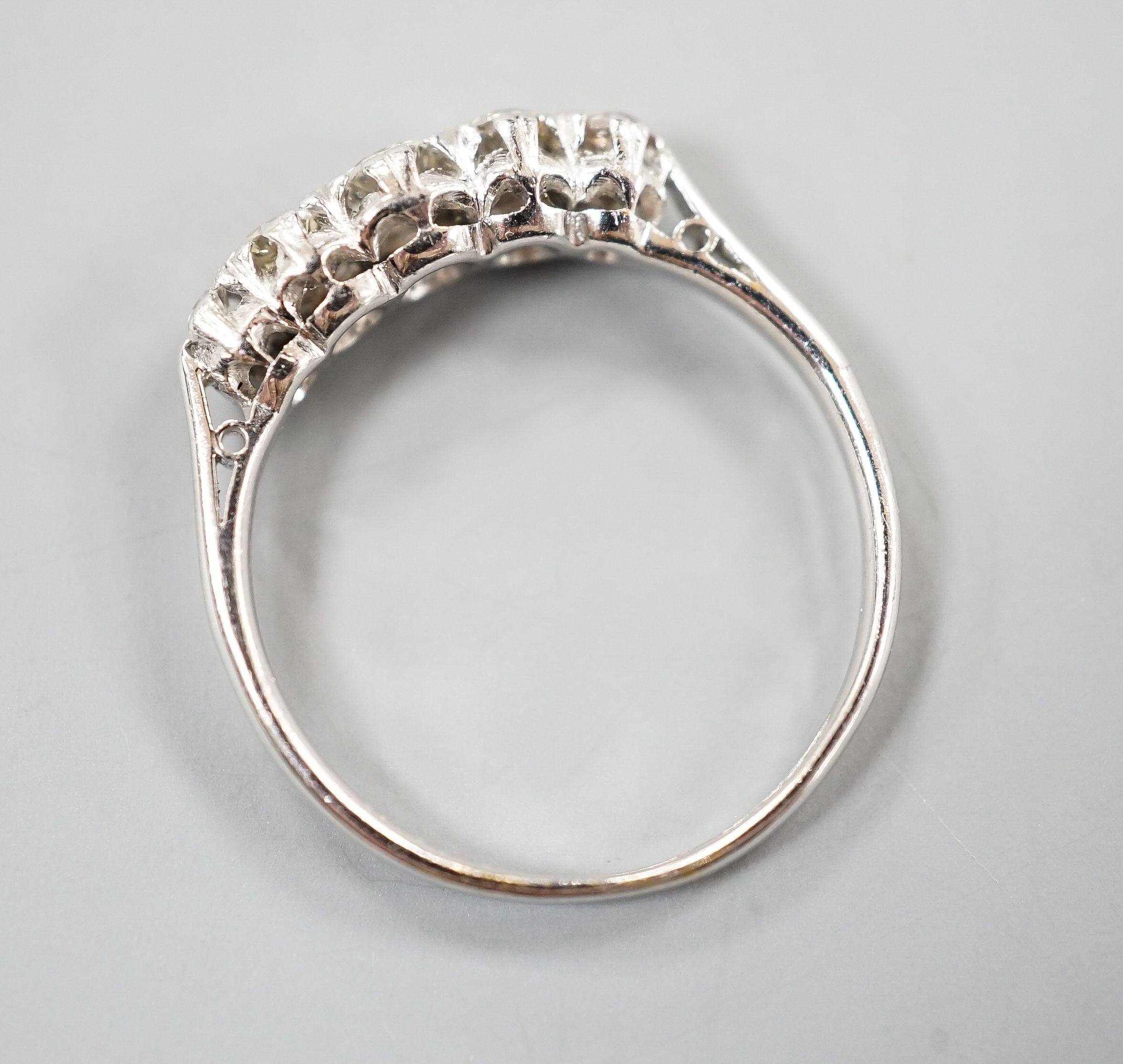 An 18ct & plat, graduated five stone diamond half hoop ring, size L/M, gross weight 2 grams.